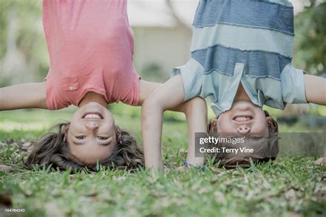 Hispanic Brother And Sister Doing Headstands In Grass High Res Stock