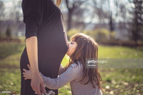 Joli Jeune Fille Embrassant Le Ventre De Sa Mère Enceinte Photo Getty