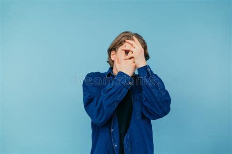 Frightened Guy In A Shirt Covers His Face With His Hands And Peeps