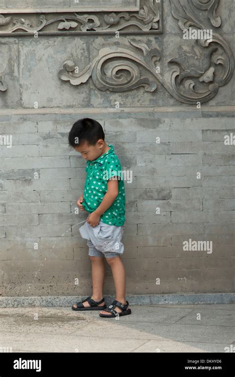 Chico orinando en el suelo Xi an Shaanxi China Fotografía de stock