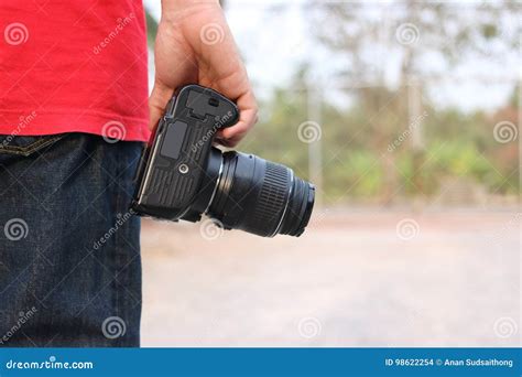 Back View Of Young Photographer Holding Camera On Hands With Copy Space