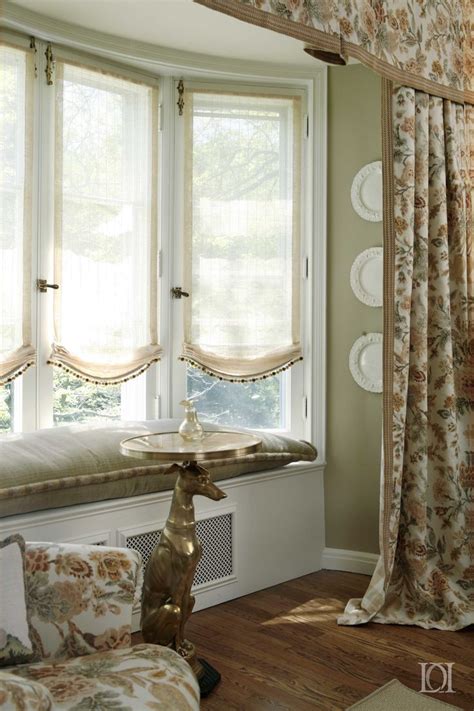 Window Seat With Sheer Roman Shades And Floral Linen Curtain Panels