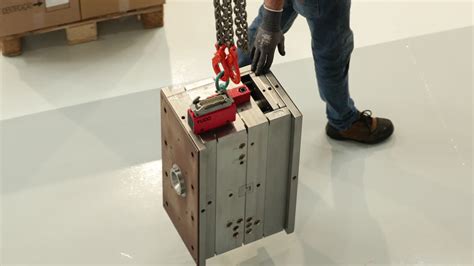 premium stock video worker transporting an injection mold by an overhead crane in the factory