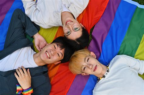 Top View With Group Of Young Lgbt Men And Women Lying Down On Rainbow Flags 照片檔及更多 20歲到24歲 照片