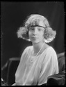 an old black and white photo of a woman with curly hair, wearing a ...