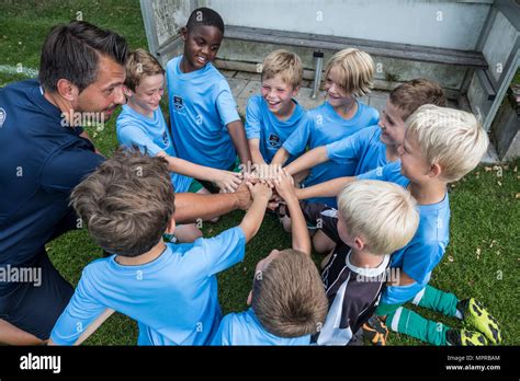 Coach And Young Football Players Huddling Stock Photo Alamy