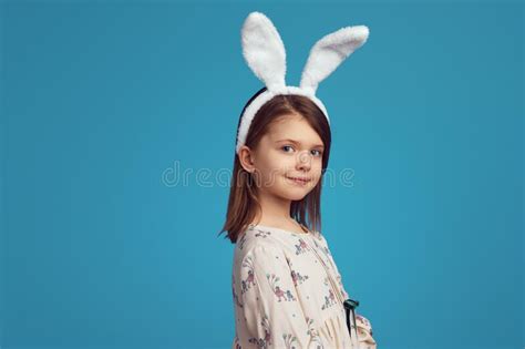 Pretty Little Girl In White Shirt And Bunny Ears Posing Adorably On