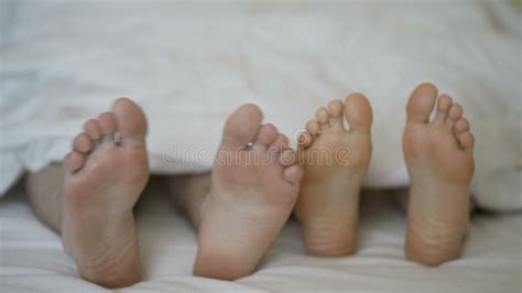 Closeup Of Young Beautiful And Loving Couple Hug And Play Their Feet