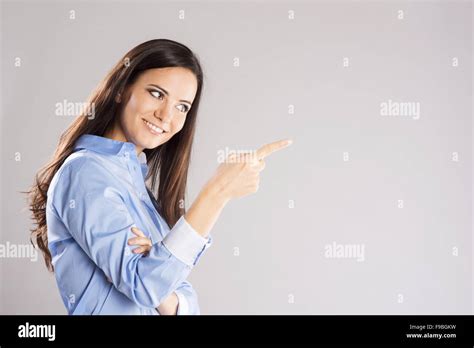 Beautiful Young Woman Pointing To Somewhere Isolated Over A White