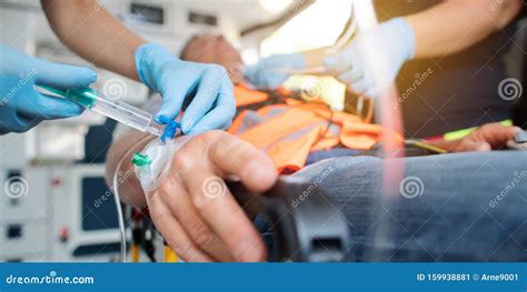 Emergency Doctor Administering Injection Needle In Ambulance Stock