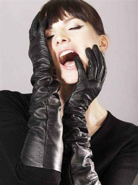 A Woman Wearing Black Gloves And Holding Her Hands Up To Her Face