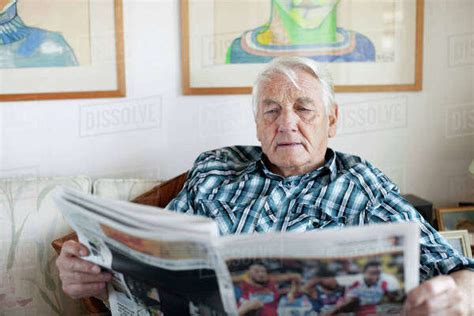 Senior Adult Man Reading Newspaper In Living Room Stock Photo Dissolve