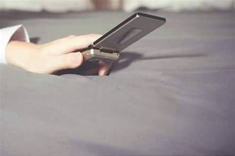 A Person Is Holding An Electronic Device In Their Hand While Laying On