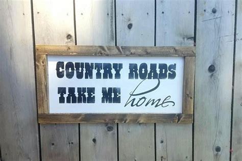 A Wooden Sign That Says Country Roads Take Me Home