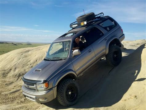 An Suv Is Driving Through The Sand Dunes In The Desert With Its Roof