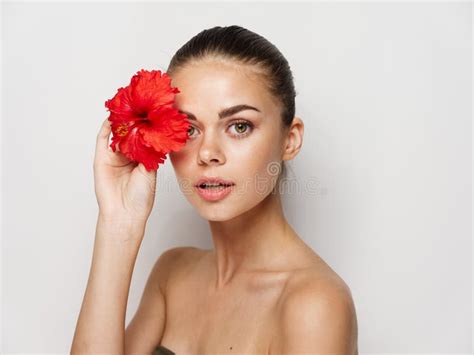 Pretty Woman Nude Shoulders Red Flower Near Face Cosmetics Stock Photo