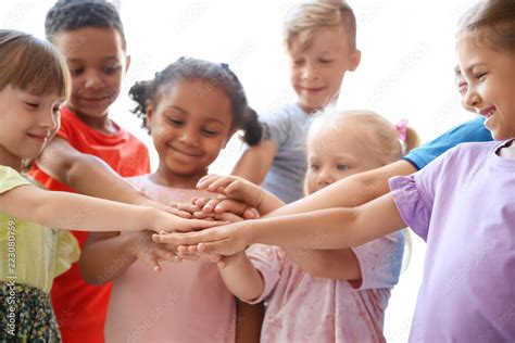 Little Children Putting Their Hands Together On Light Background Unity