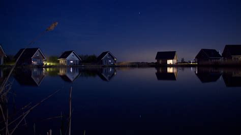 3840x2160 Houses At Lake Water Starry Night 4k Wallpaper