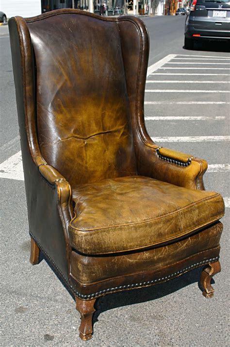 A wingback chair is easily recognized by its distinct features such as winged sides that extend from the side of a high backrest. High Leather Wingback Chair at 1stdibs