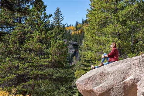 Woman Sitting On Rocky Ledge In Rocky Mountain National Park Near Bear