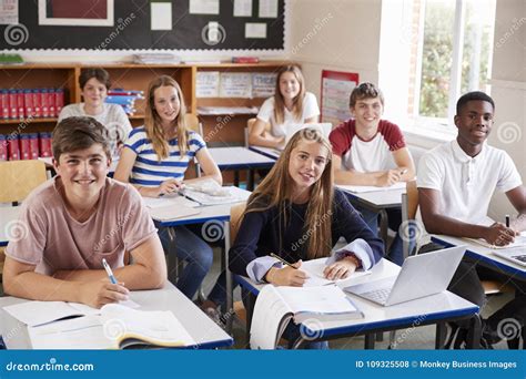 Portrait Of Students Sitting At Desks In Classroom Stock Photo Image