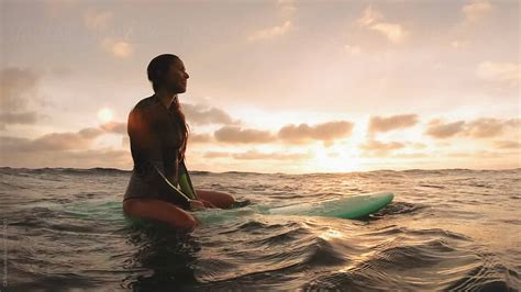 Surfer Girl Sitting On Surfboard At Sunset Waiting For Waves Del