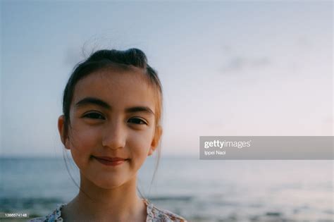 Cute Young Girl Looking At Camera On Beach At Sunset High Res Stock
