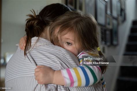 Young Girl Gripping Tightly To Her Mother In A Reassuring Embrace With Her Arms Wrapped Around