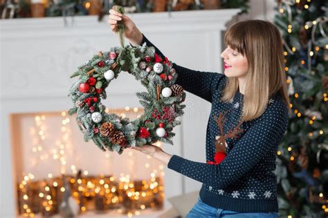 Young Woman Holding A Christmas Wreath With Fir Branches For The