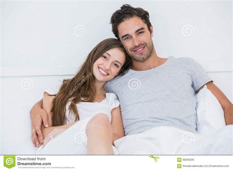 Portrait Of Happy Couple Sitting On Bed Stock Photo Image Of Length