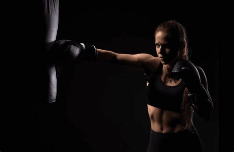 A Woman Wearing Boxing Gloves And Holding A Punching Glove In Her Right