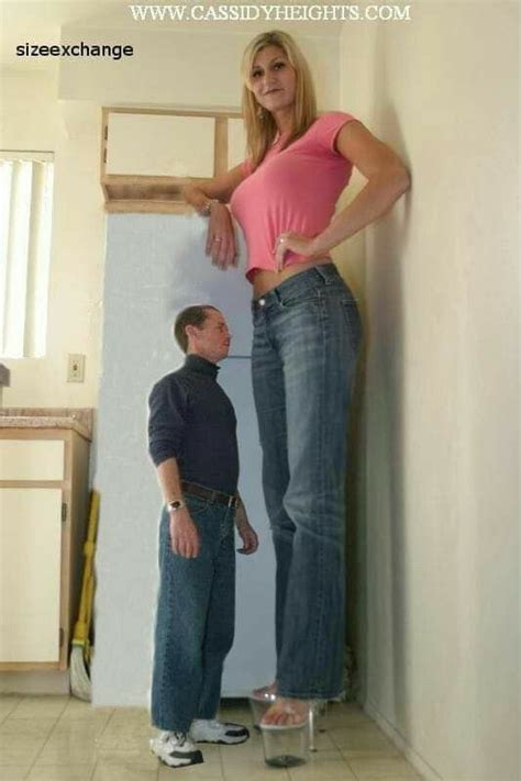 A Man Standing Next To A Woman Wearing High Waisted Jeans And Pink Crop Top