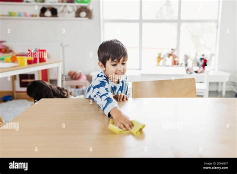 Boy Cleaning Dining Table At Day Care Center Stock Photo Alamy