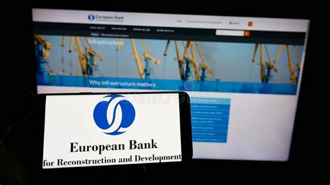 Person Holding Cellphone With Logo Of European Bank For Reconstruction And Development Ebrd On