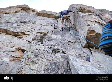 A Climber Hanging From The Rope Descending A Rock Wall Stock Photo Alamy