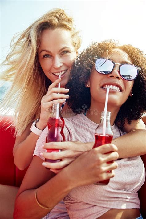 two girlfriends laughing over drinks on a boat during vacation stock image image of looking