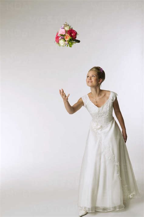 Young Bride Tossing Bridal Bouquet Stock Photo