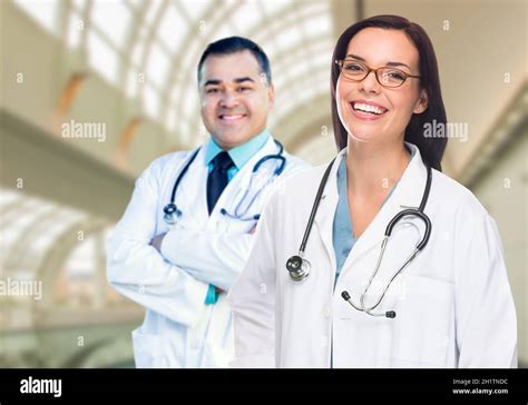 Two Male And Female Doctors Or Nurses Standing Inside Hospital Building