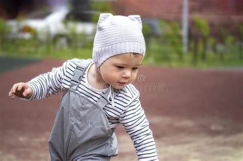 Baby Girl Boy 1 Year Old In Gray Hat And Pants With Straps For A Walk