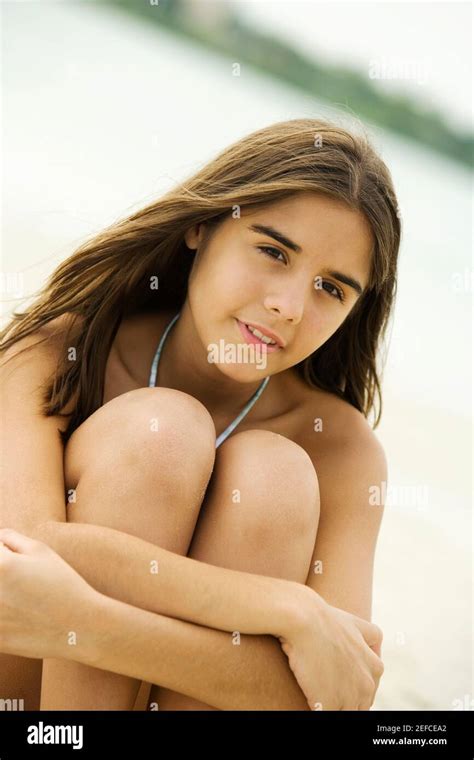 Portrait Of A Teenage Girl Sitting On The Beach Smiling Stock Photo Alamy