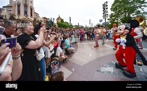 An Entertainer Dressed In A Mickey Mouse Costume Interacts With