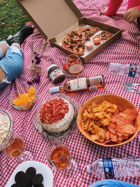 A Picnic Table With Food Drinks And Snacks Laid Out On The Grass In