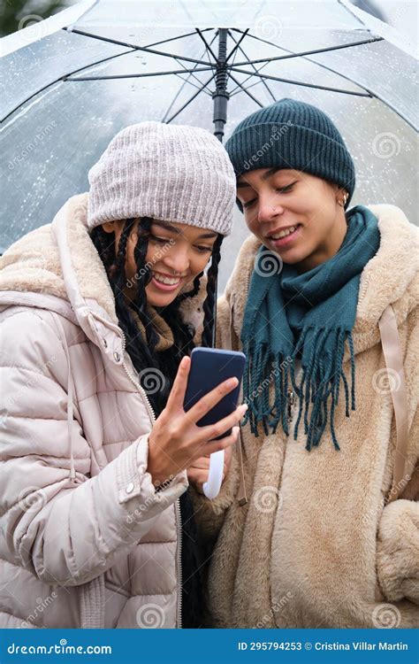 Happy Dominican Lesbian Couple Using The Phone In A Rainy Day Of Winter Stock Image Image Of