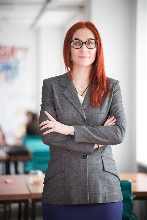 Education Concept Smiling Ginger Teacher Woman Standing In The Office