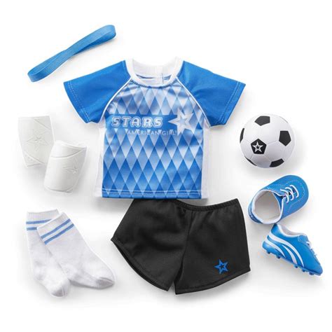 a toy soccer uniform with shoes socks and ball on a white background for dolls