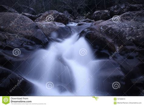 Slow Shutter Speed Photography Of A Rushing Waterfall Of River Rocks