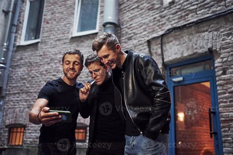 Three Male Friends Stands Outside The Bar Having Conversation In Nice