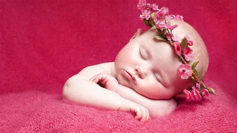 Cute Baby Is Sleeping On Red Towel And Having Flower Crown On Head In