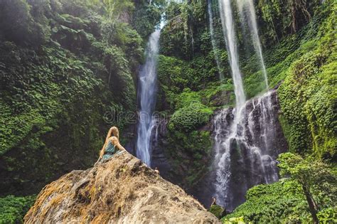 Woman In Turquoise Dress At The Sekumpul Waterfalls In Jungles On Bali