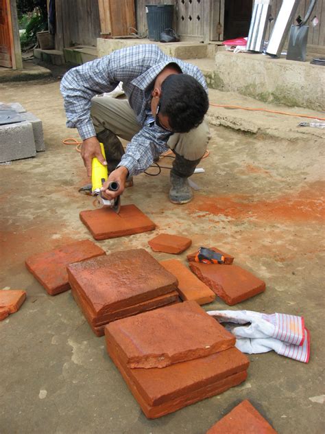 Move the handle away from the edge of the tile so that the draw a curved line with a pencil where you want to cut the tile. Cutting the tiles with an angles grinder. | ITACA